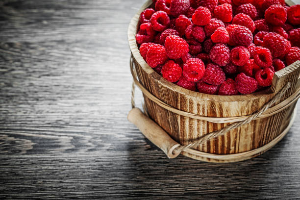 istock Bucket with juicy raspberries on wooden board 857592034