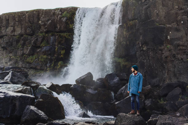 istock Man walking near   waterfall in mountains 857595734