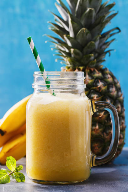 istock Smoothies from pineapple and banana in a glass jar, close-up 857599094