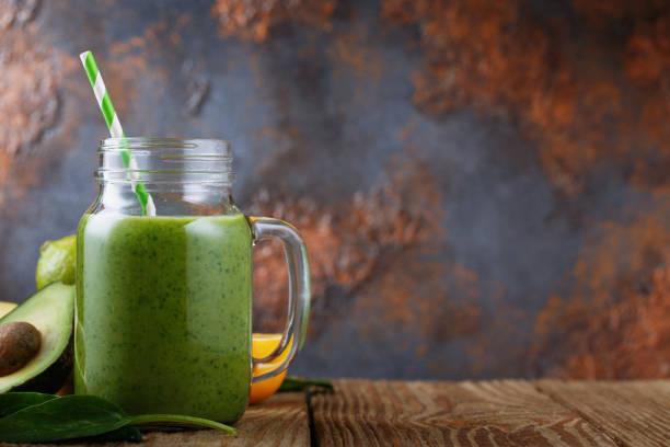 istock Smoothies of avocado, orange, lime and spinach leaves with space for text 857599702