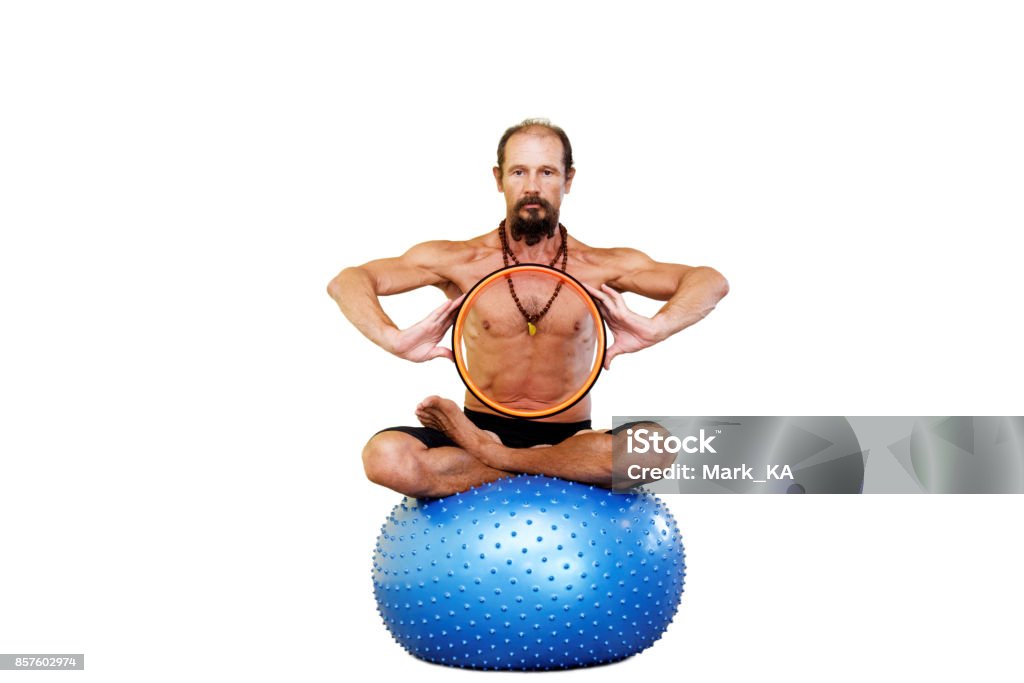 Yogi-Mann praktizieren Yoga mit Pilates Ring am Fitness-Ball in Lotus-Pose. - Lizenzfrei Aktiver Lebensstil Stock-Foto