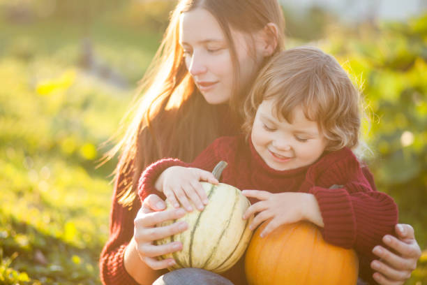 istock Mother and child choosing pumpkins for jack-o-lantern. 857605912