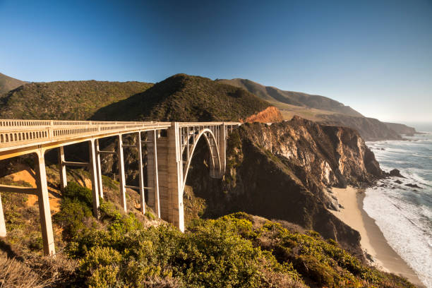 Monterey: Bixby Bridge on highway 1 near the rocky Big Sur coastline of the Pacific Ocean California, USA.  Bixby Creek Bridge, also known as Bixby Bridge, on the Big Sur coast of California, is one of the most photographed bridges in California.