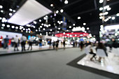 Blurred, defocused background of public event exhibition hall. Business trade show or commercial activity concept