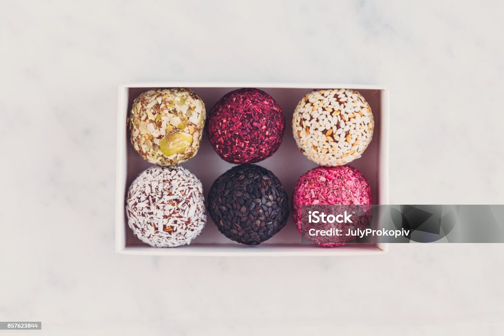 Box of energy raw bites on white marbe table from above Above Stock Photo