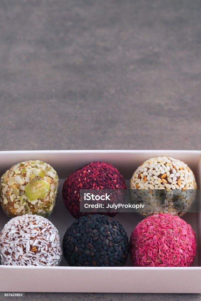 Energy raw bites on dark table Box of energy raw bites on dark table from above. Copy space Above Stock Photo