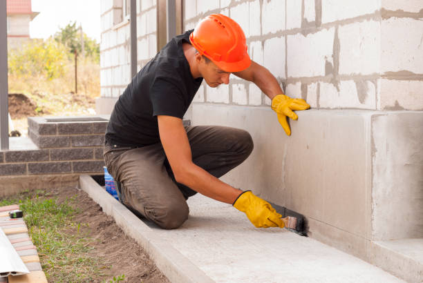 bitumen waterproofing of the foundation worker applies bitumen mastic on the foundation waterproof stock pictures, royalty-free photos & images