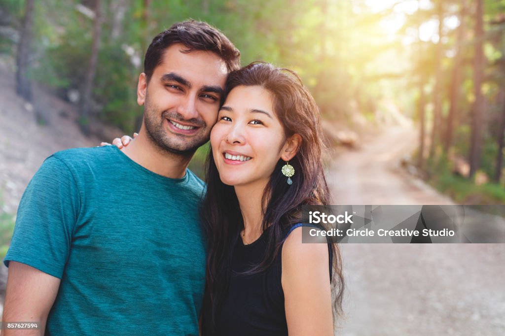 Young Japanese Woman and Indian Man Couple Young Japanese Woman and Indian Man Couple looking at the camera and smiling. Couple - Relationship Stock Photo