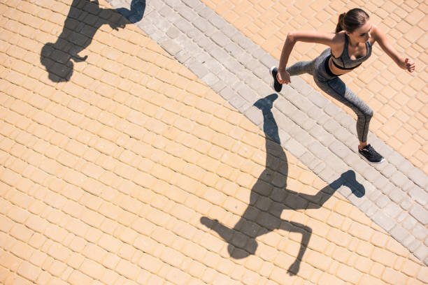 istock woman jogging on street 857630638