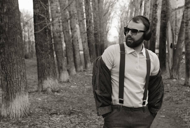 istock monochrome beard man listen music in park 857630758