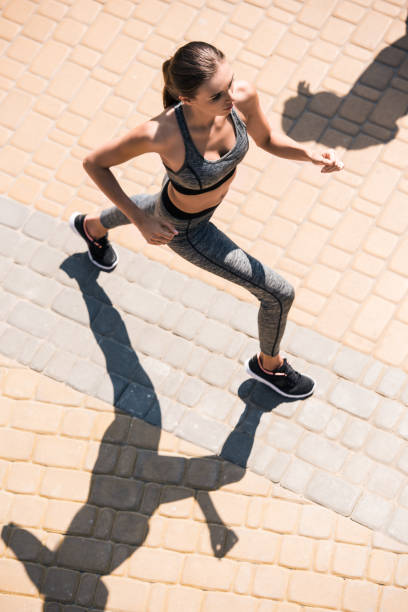 istock woman jogging on street 857630916