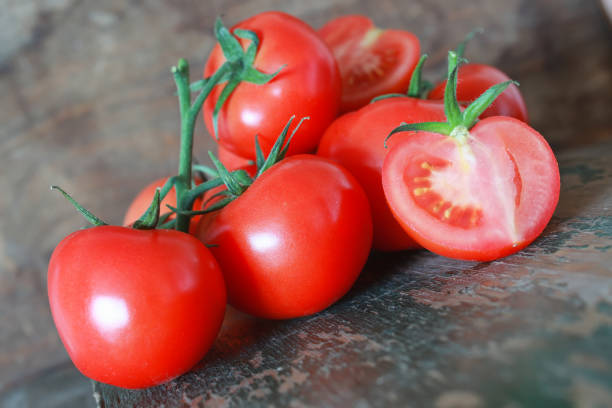 istock branch of tomatoes on wooden background 857631164