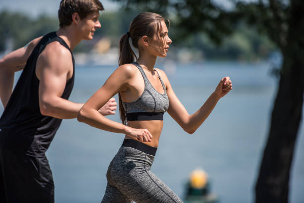 istock sportive couple jogging in park 857631174