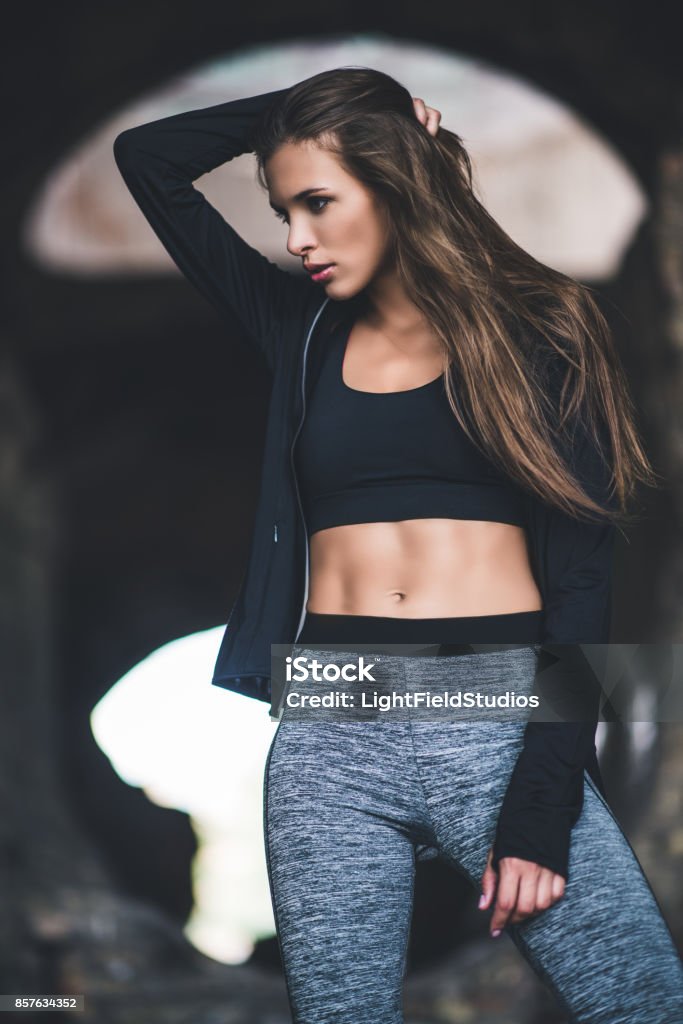 young woman in sportswear portrait of young woman in sportswear and hoodie looking away Active Lifestyle Stock Photo