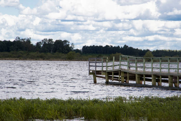 istock boats and dock on river very grown sky with clouds 857638616