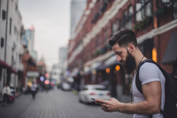 istock Hipster man using phone outdoors 857641640