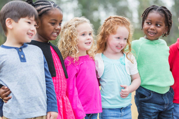 istock Multi-ethnic group of young children standing in the park 857643012