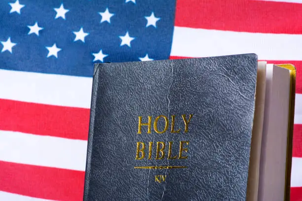 Black Holy Bible in front of the American flag.