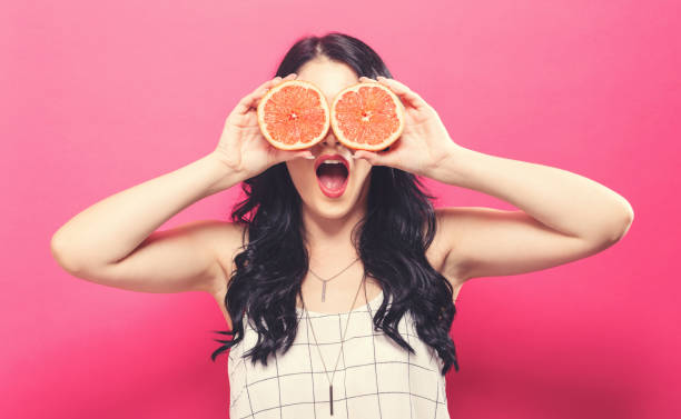 istock Happy young woman holding oranges 857674928