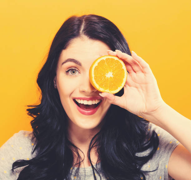istock Happy young woman holding oranges 857675010