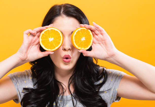 istock Happy young woman holding oranges 857675016