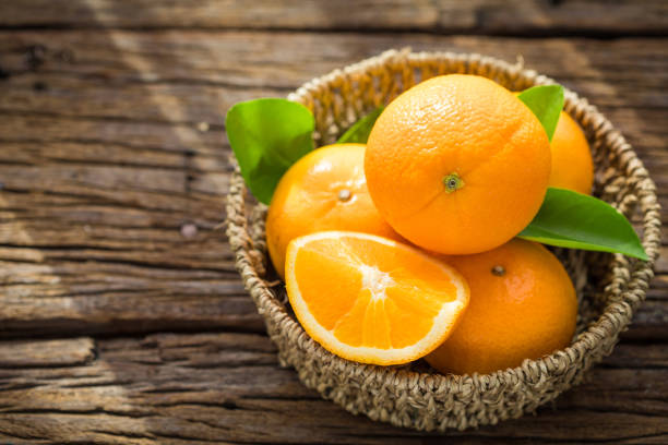 istock Fresh orange fruits in basket on wood table. 857679114