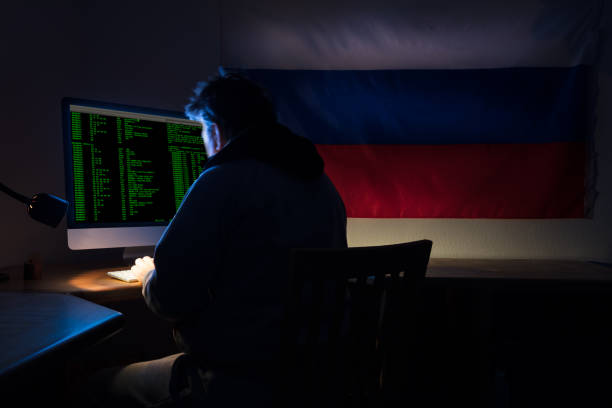 Computer Hacker Computer hacker in room with computers looking at camera +++ text on computer was generated by photographer and is copyright free +++ cracker stock pictures, royalty-free photos & images