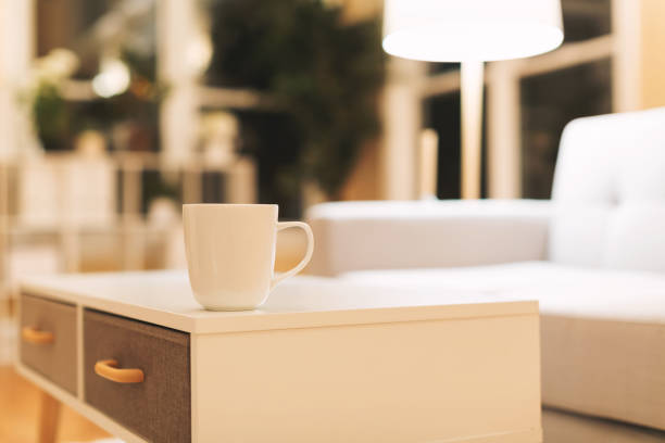 istock Coffee cup and gray midcentury loveseat 857701548