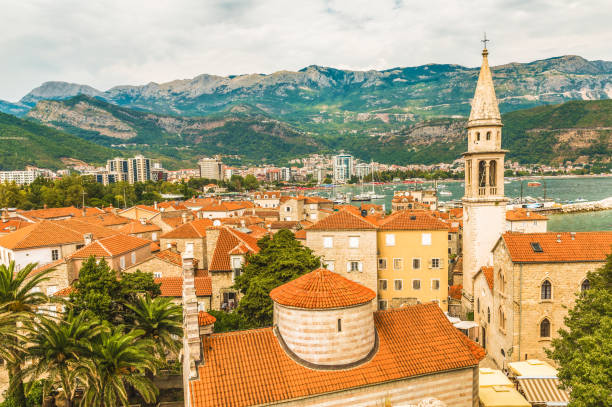 krajobraz starego miasta budva: starożytne mury i czerwony dachówka. czarnogóra, europa. budva - jeden z najlepiej zachowanych średniowiecznych miast w basenie morza śródziemnego i najbardziej popularnych kurortów riwiery adriatyckiej. - surf scene zdjęcia i obrazy z banku zdjęć