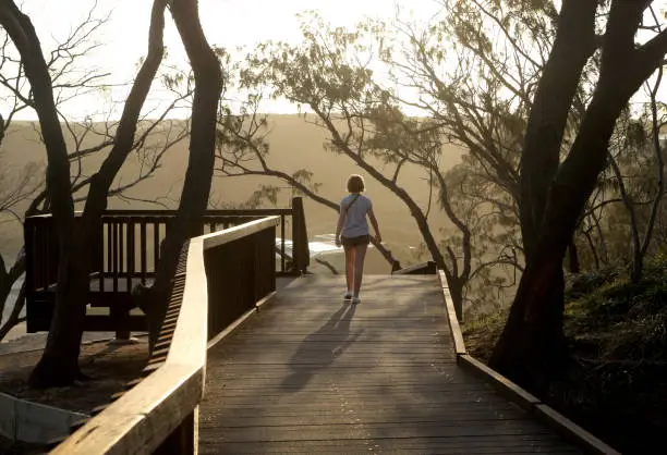 Photo of A girl walks on the boardwalk at the Gorge walk on North Stradbroke Island at Sunset