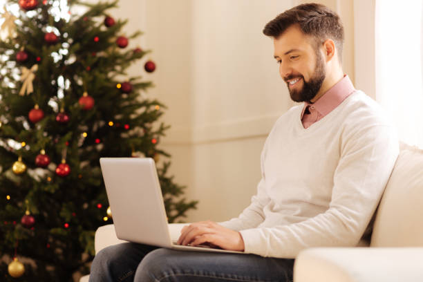 istock Handsome man working on laptop in room with Christmas tree 857711598