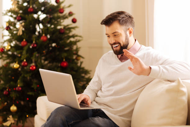 istock Happy man making a video call in room with Christmas tree 857711738