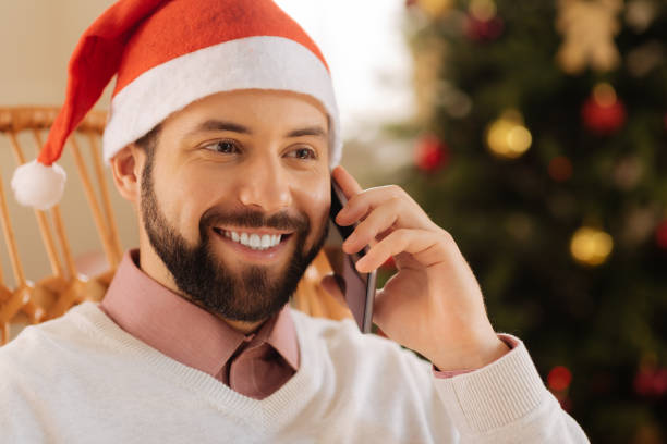 istock Close up of smiling man in Santa hat calling someone 857715334