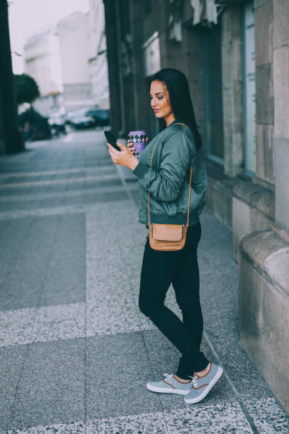 istock Woman texting and drinking coffee outdoors 857716176