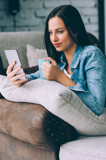 istock Woman texting and drinking coffee at home 857716192