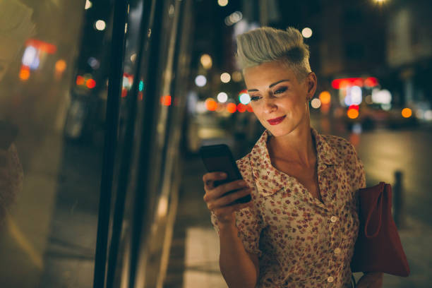 istock Elegant woman texting at night 857716230