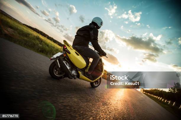 Man Riding Scooter During Sunset Stock Photo - Download Image Now - Motor Scooter, Motorcycle, Riding