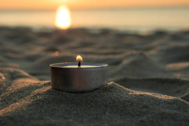 istock Sunrise with a candle on the beach 857723278