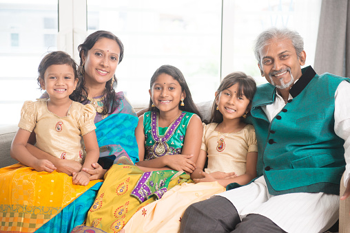 Portrait of happy Indian family at home, smile at camera.