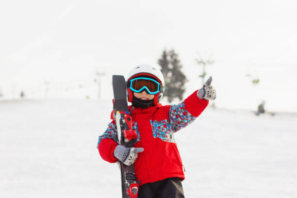 istock Little cute boy with skis and a ski outfit. 857725474
