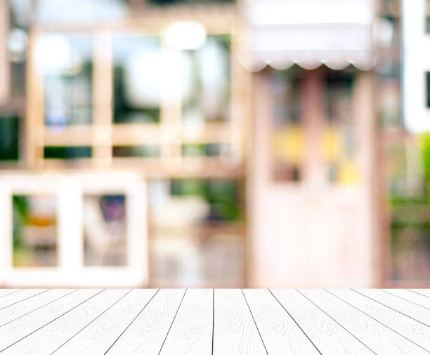 istock Empty white table, perspective wood, over blurred store with bokeh background, product display montage background 857725946