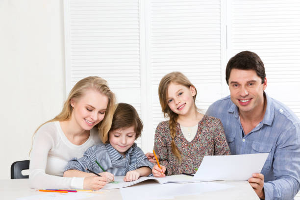 istock Parents and cute children with colored pencils and laugh. 857732914