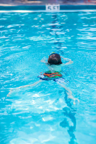 istock Little kid boy making swimming competition in pool 857736166