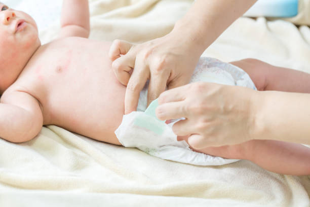 istock Mother putting diaper on her baby 857743866