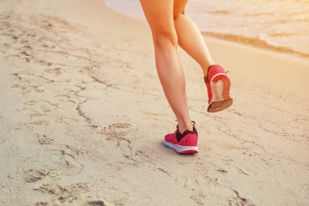 istock Runner woman running on beach in sunrise 857755436