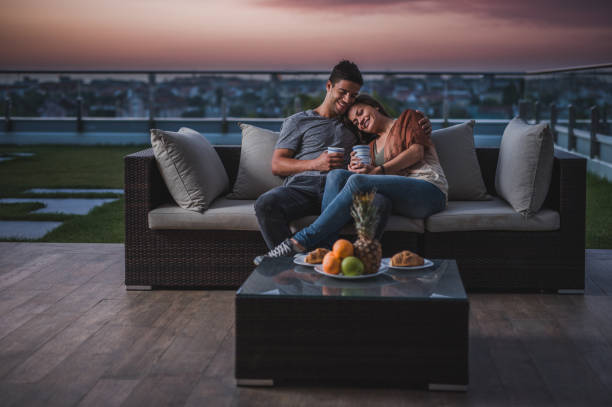 istock Young affectionate couple relaxing on a penthouse balcony at twilight. 857756442