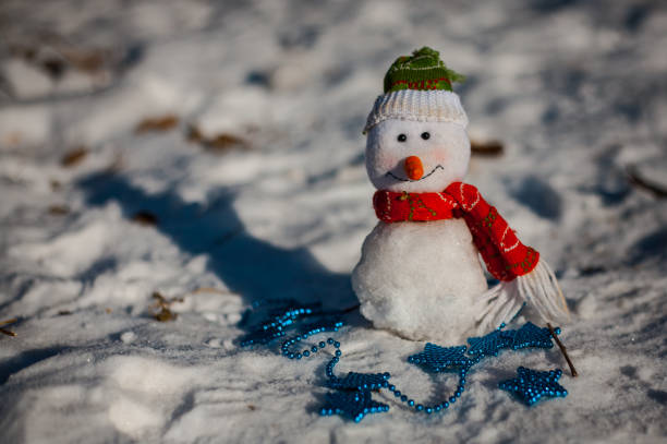 istock Snowman on snow over blurred christmas tree and gift box on glitter light bokeh background with copy space 857758916