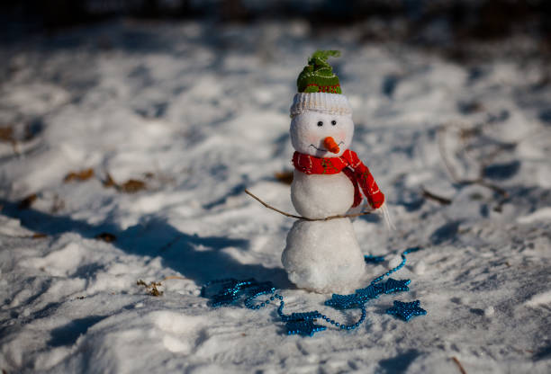 istock Snowman on snow over blurred christmas tree and gift box on glitter light bokeh background with copy space 857759042