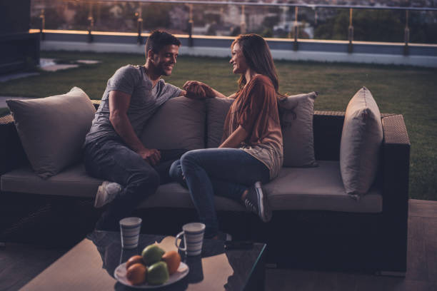 istock Happy couple relaxing on a penthouse patio while holding hands and talking. 857762590