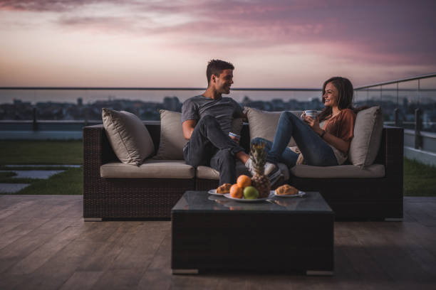istock Happy couple relaxing on a patio at twilight and communicating. 857763434